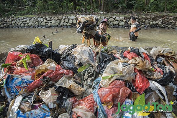 Dua pekerja Dinas Lingkungan Hidup Jakarta sedang membersihkan sampah plastik yang tersangkut dibant